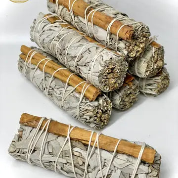 7 Bundles of Sage and Cinnamon, each secured with string. placed on light gray background