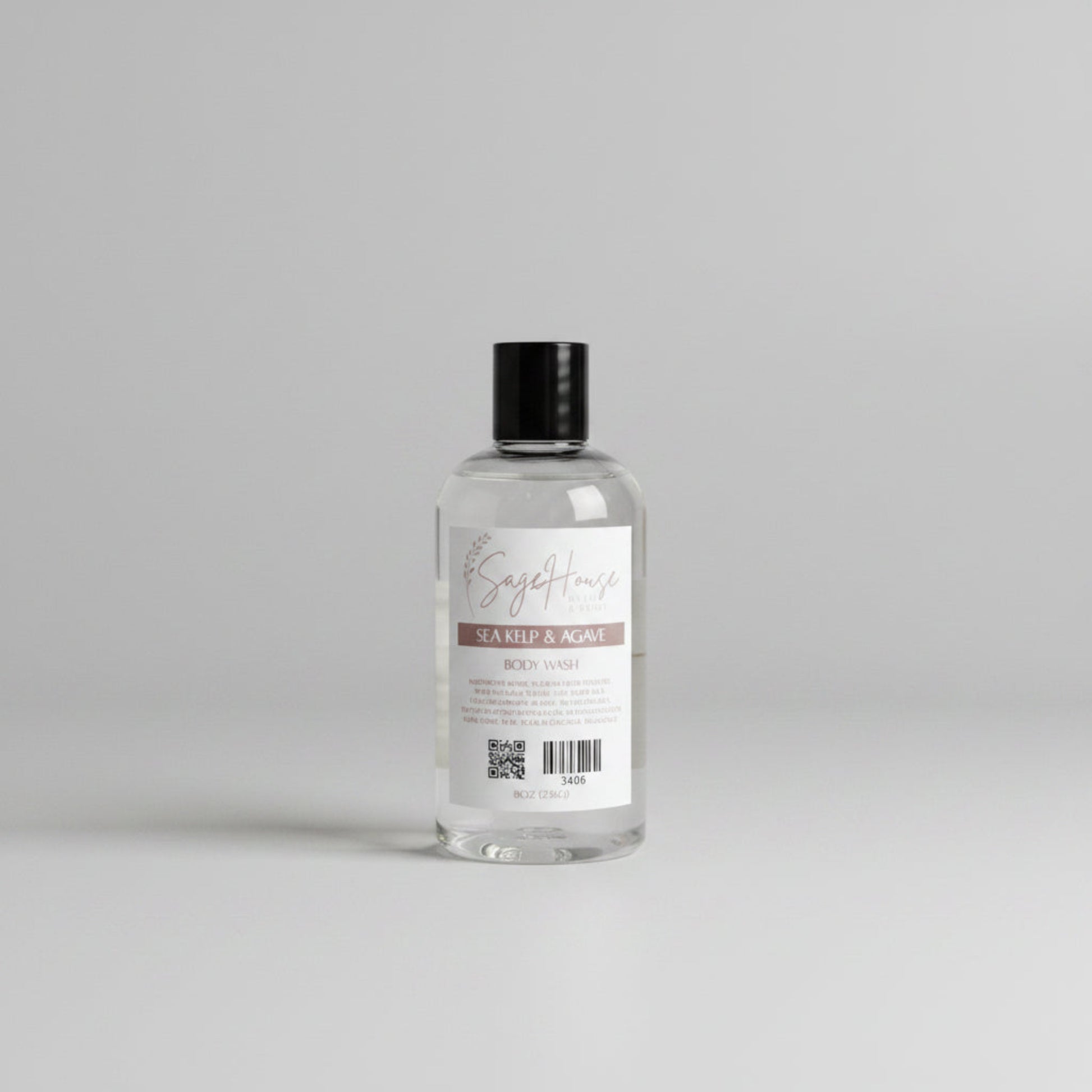 Bottle of "sea kelp & agave" body wash on a wooden surface with a light background