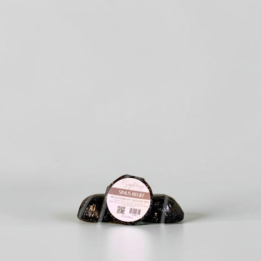 One labeled shower melt propped in front of 2 other shower melts. Sitting on a white background.