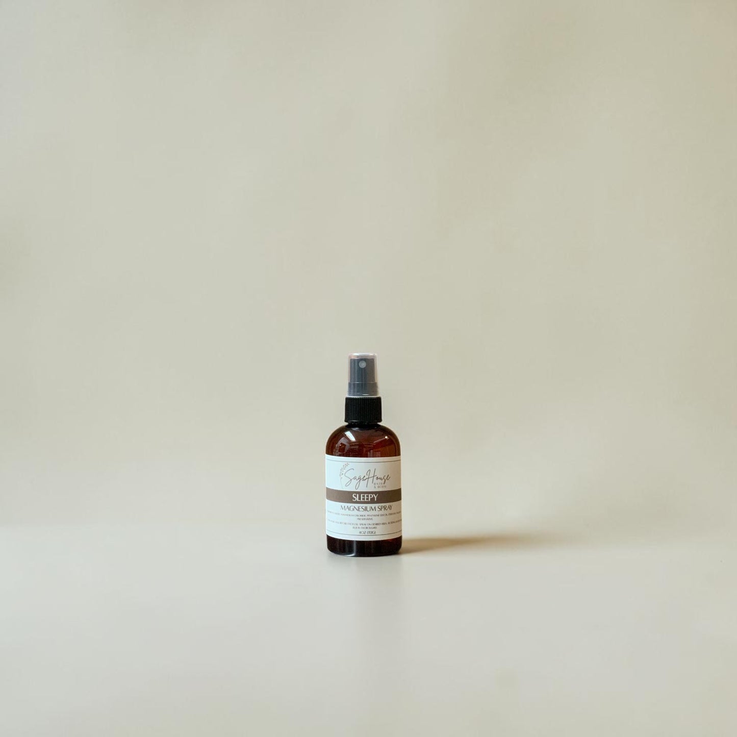 Small brown spray bottle with a label on a beige background