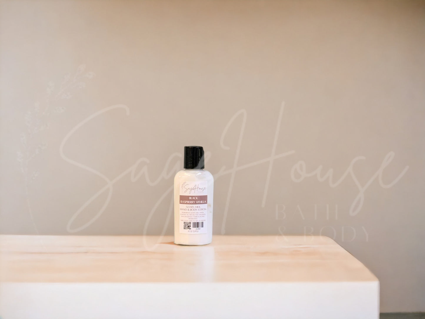 A small bottle of lotion with black cap on a wooden surface with a neutral background
