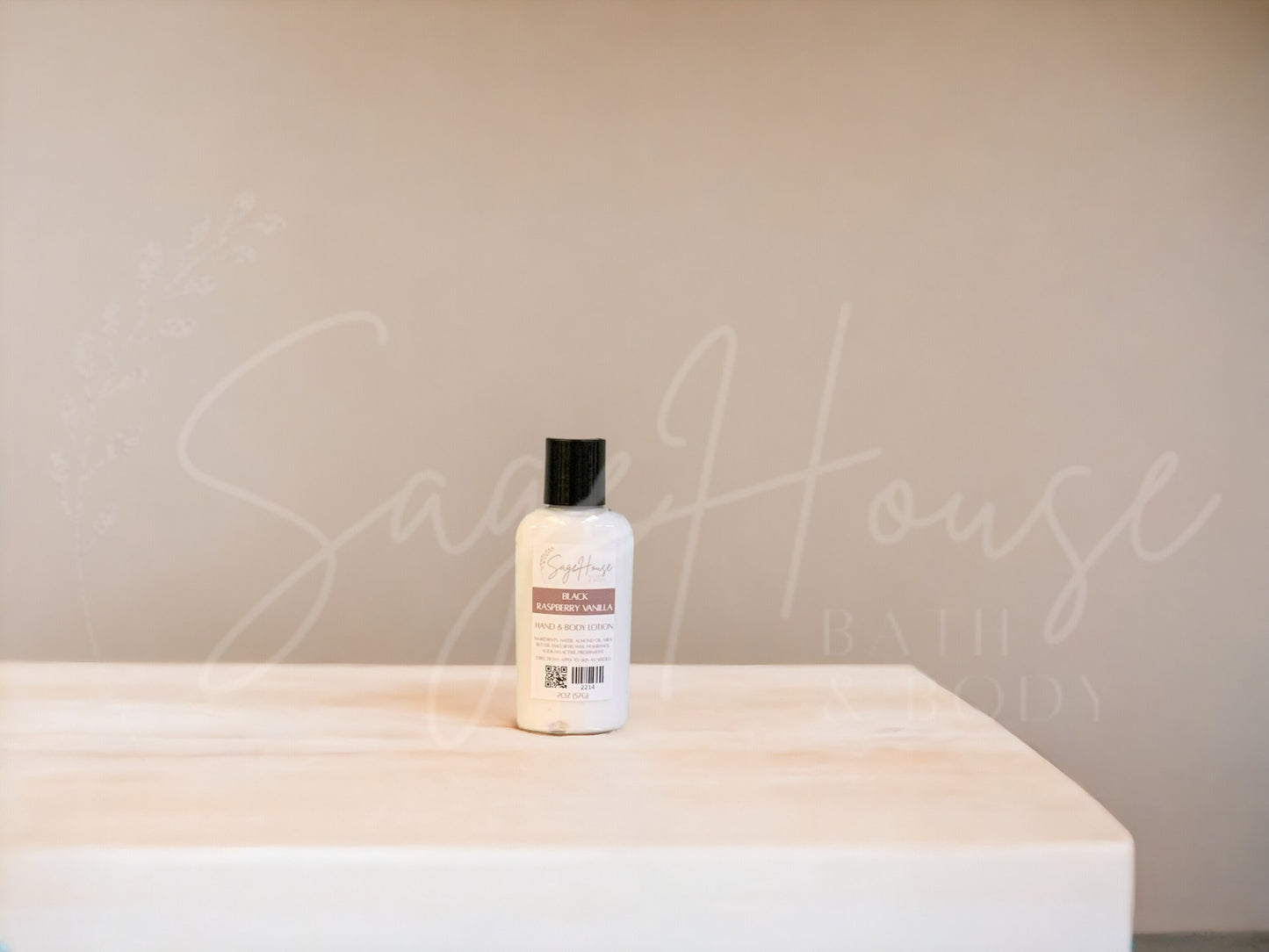 A small bottle of lotion with black cap on a wooden surface with a neutral background