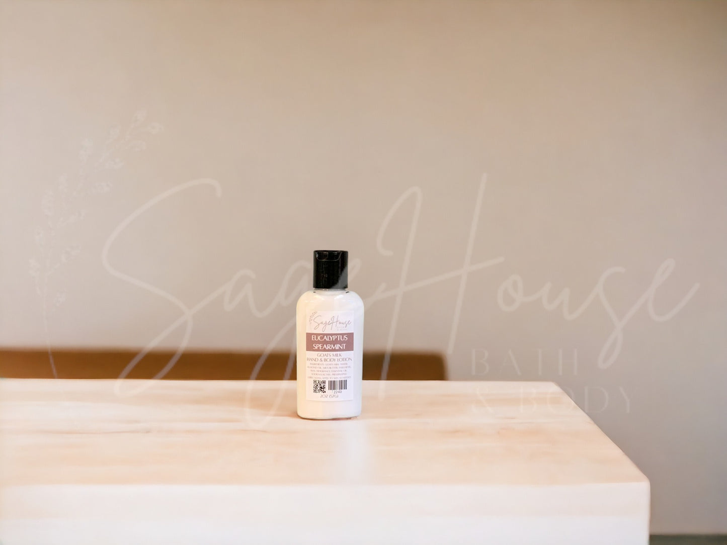 A small bottle of lotion with black cap on a wooden surface with a neutral background