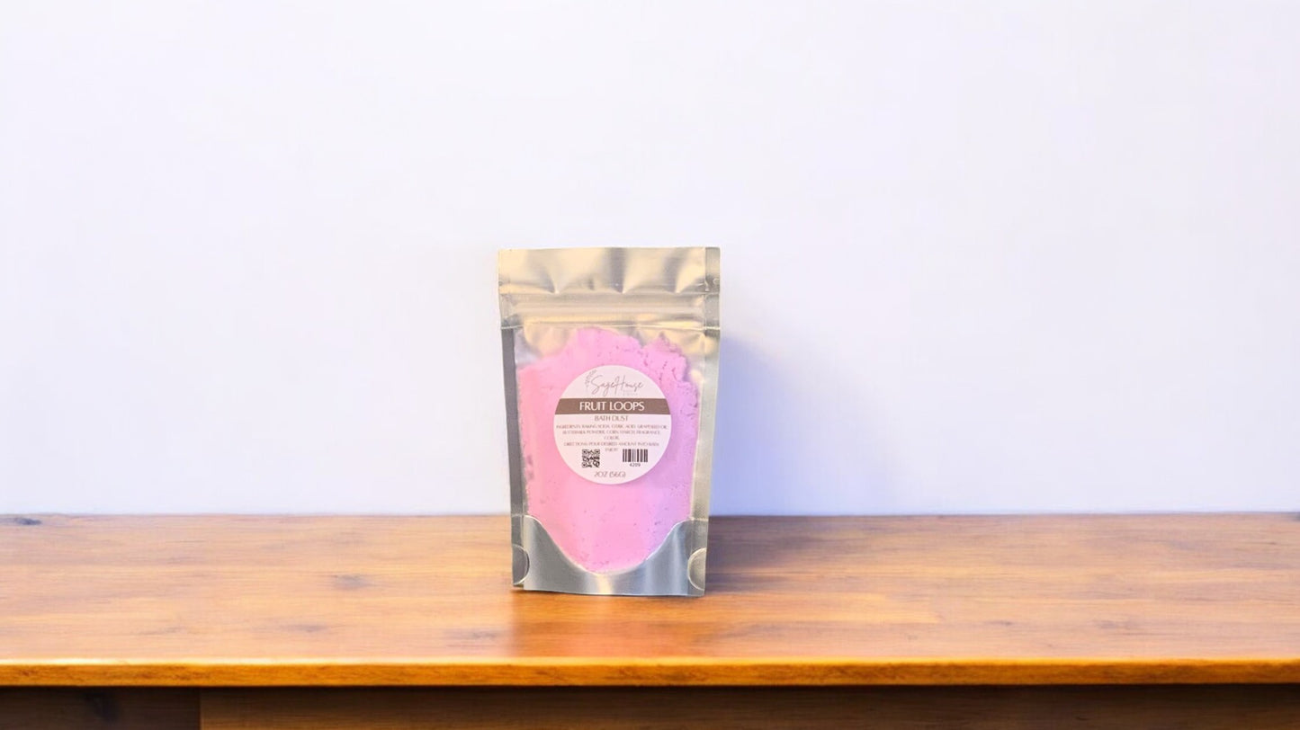 A purple-colored bath bomb in clear packaging, labeled 'fruit loops'. The bath bomb is placed on a wooden surface.