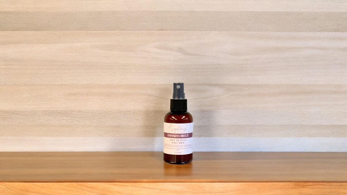 Amber colored spritz bottle with hawaiian breeze label, on wood surface