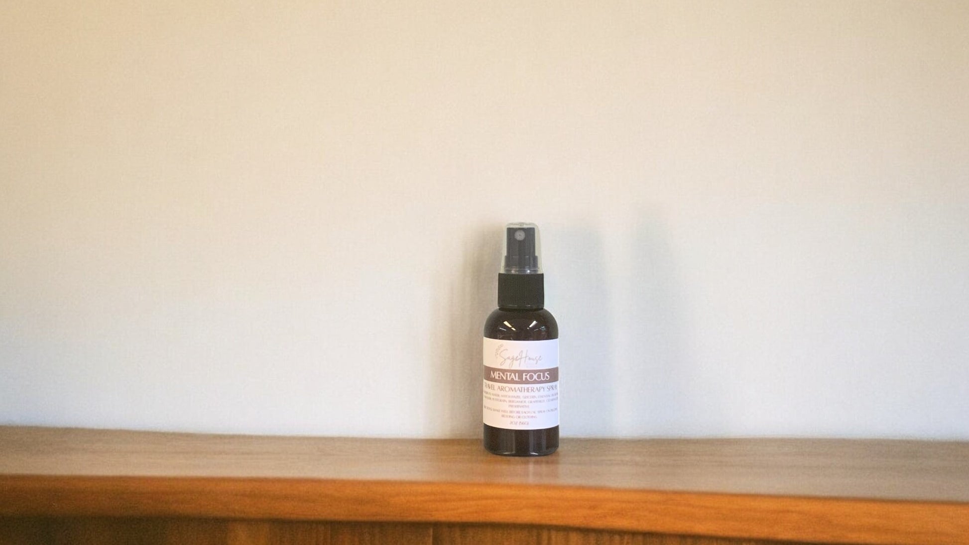 Amber colored spritz bottle with mental focus label, on wood surface