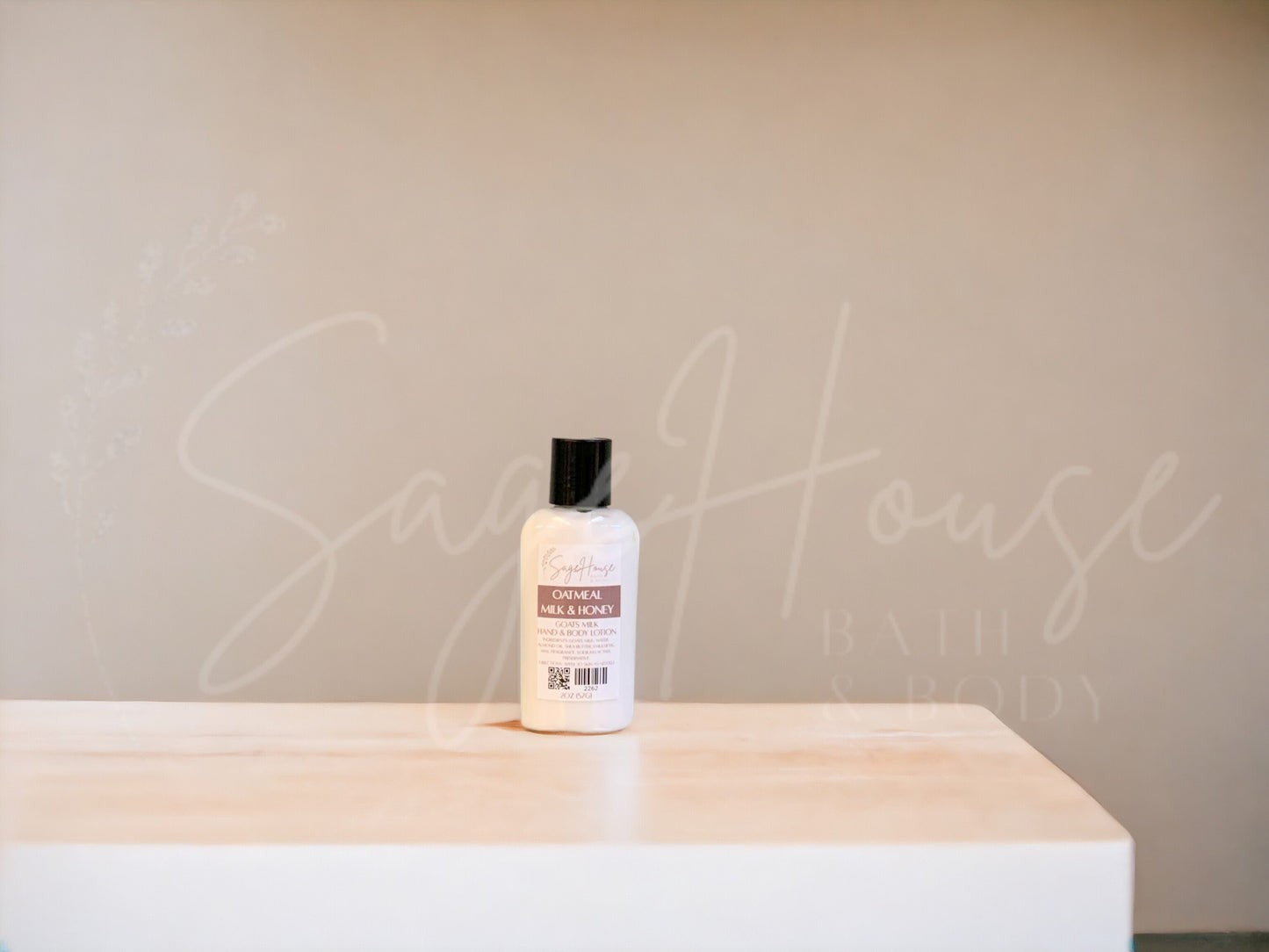 Small bottle of lotion with black cap on a wooden surface with a neutral background