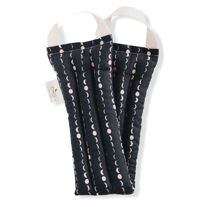 A neck wrap therapy pack with a star and moon design on a dark blue fabric. displayed on a white background.