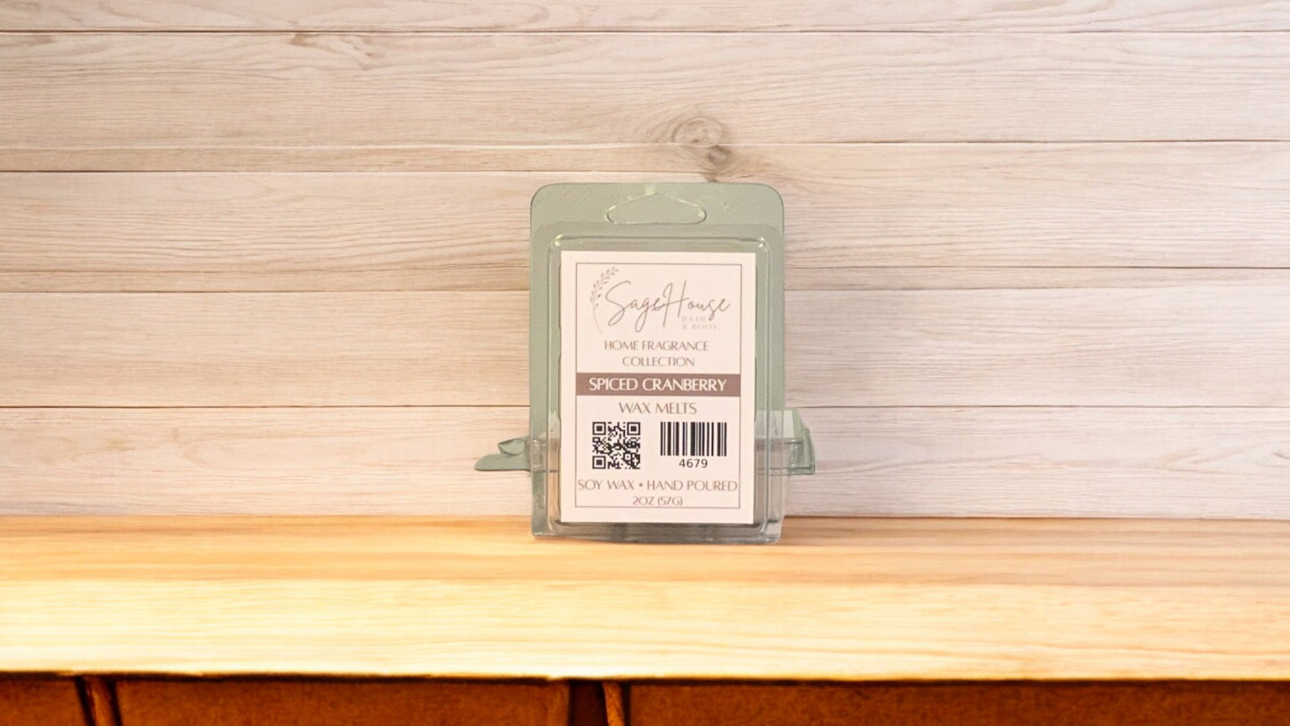 A clear clamshell container holding 6 wax melt cubes with a label on top, placed on a wooden surface against a wooden background.