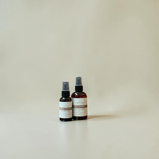 Two spray bottles with labels on a beige background