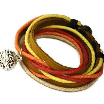 bracelet with various ropes in colors of red, yellow, orange & khaki. lava bead inside of silver ball