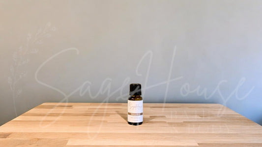 A small bottle of tangerine essential oil is placed on a wooden surface with a plain background.