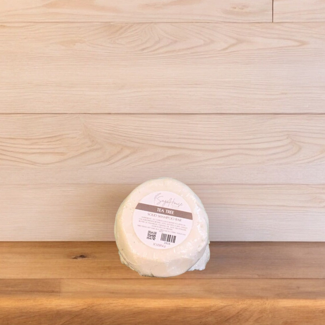 A Tea Tree shampoo bar on a wooden surface.