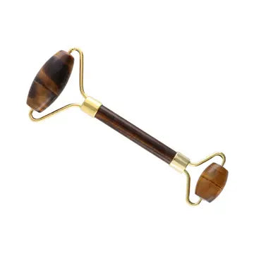 A tiger eye stone roller with gold handles and rollers on each end