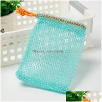 A Soap Scrub Pouch in turquoise, placed on a white surface. A basket and plant in the background.