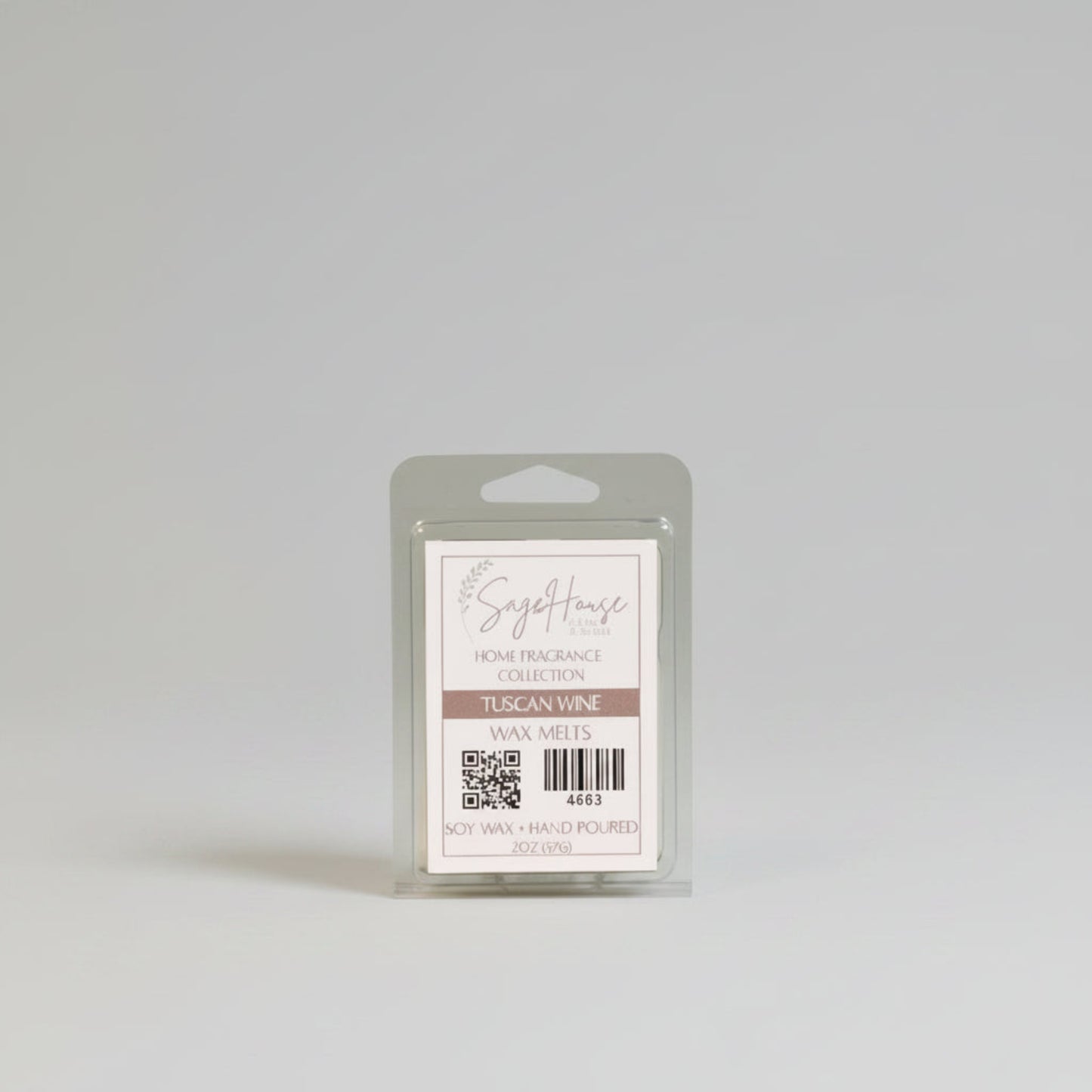 A wax melt clam shell with a white label. Sitting on a wood surface.