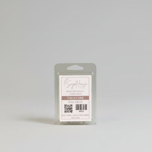 A wax melt clam shell with a white label. Sitting on a wood surface.