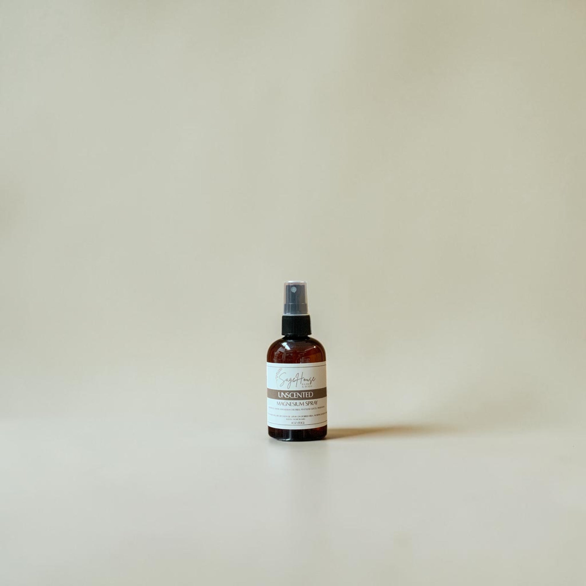 Small brown spray bottle with a label on a light beige background