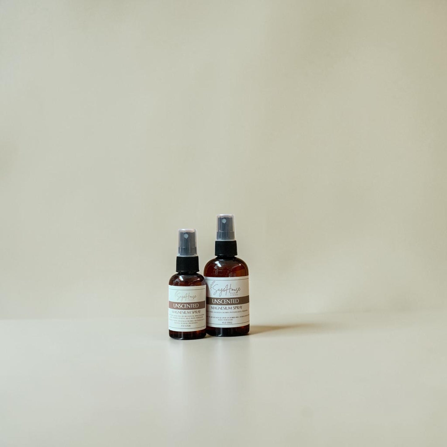 Two spray bottles with labels on a beige background