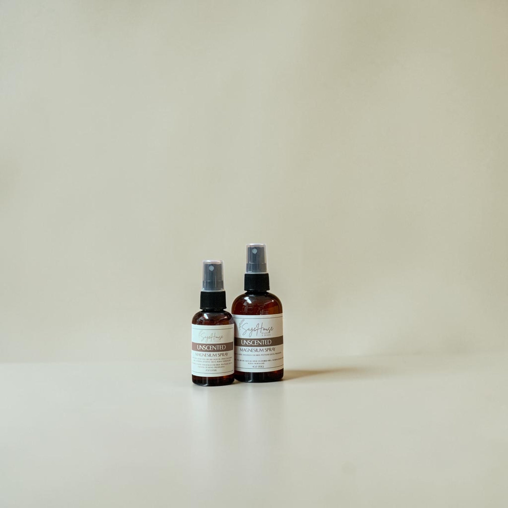 Two spray bottles with labels on a beige background