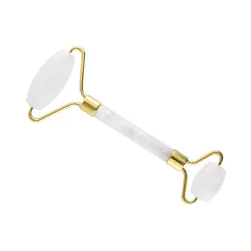 A white quartz roller with gold handles and rollers on each end