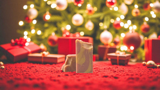 A burgundy and gold bar of soap setting on red carpet with a christmas background