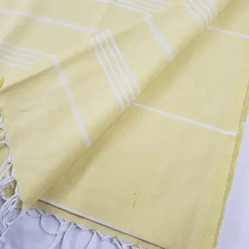 Yellow Turkish cotton towel, folded onto itself, on a white background.