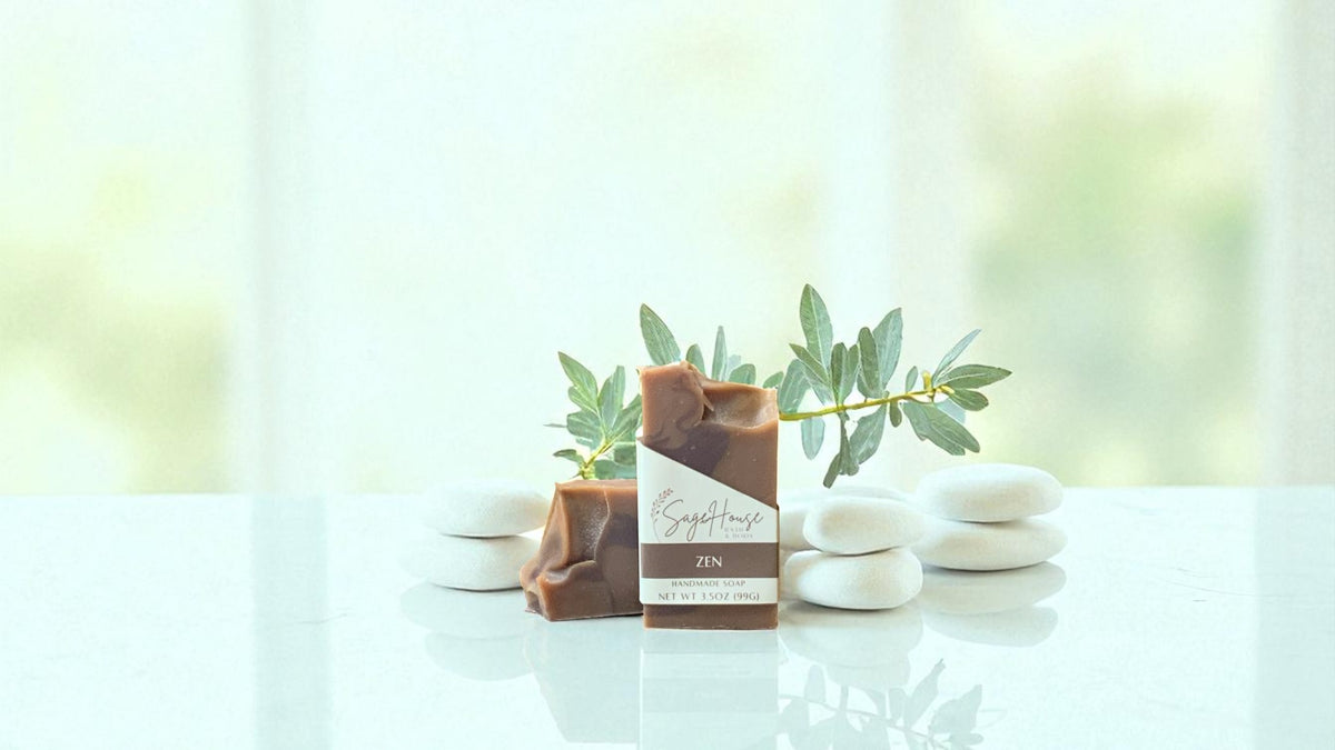 Two tone rich brown colors of bars of soap with a plant on a white surface