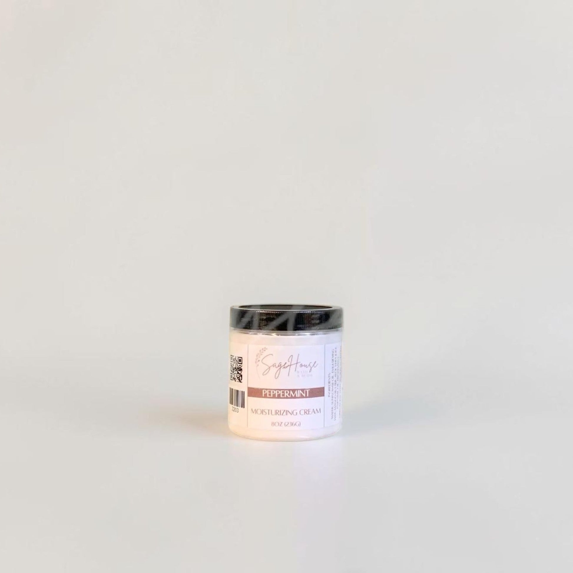 A labeled jar with a black lid. On a neutral background.